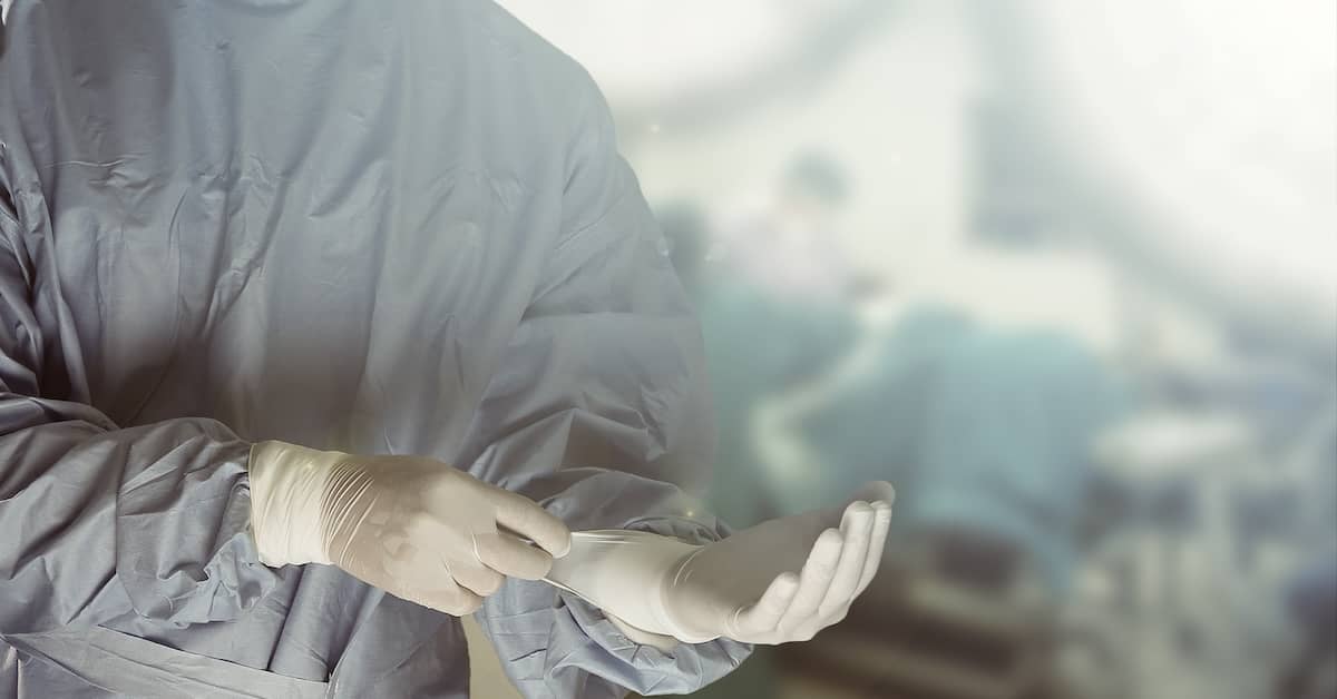 Surgeon putting on gloves