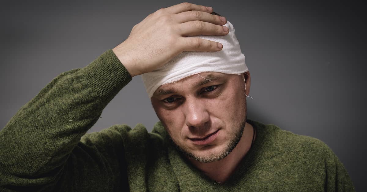 Man holding his bandaged head after a head injury in Tennessee | The Haynes Firm