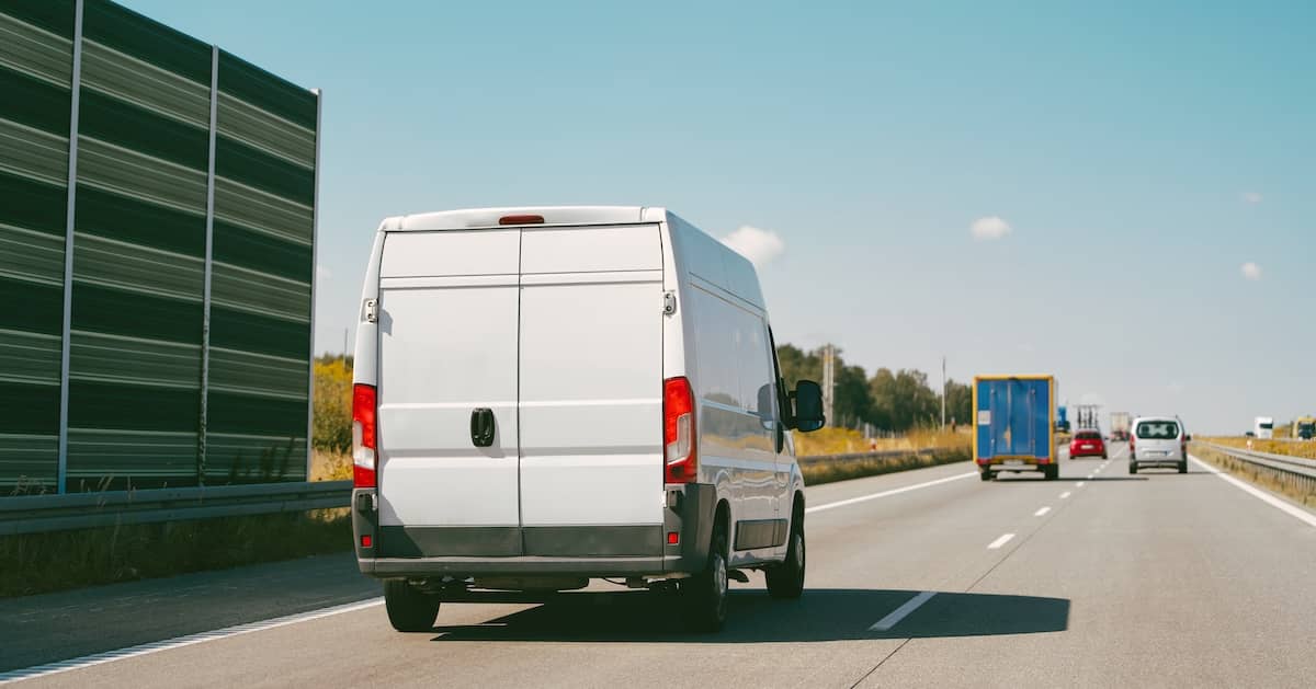 Delivery van and work truck on highway